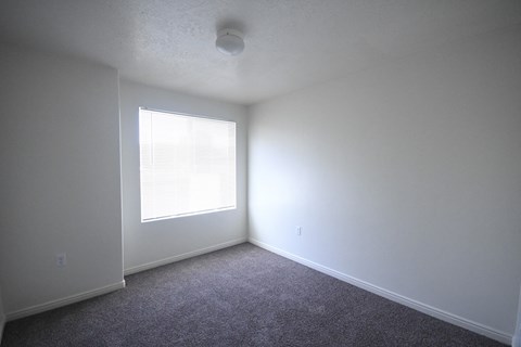 an empty room with white walls and a window
