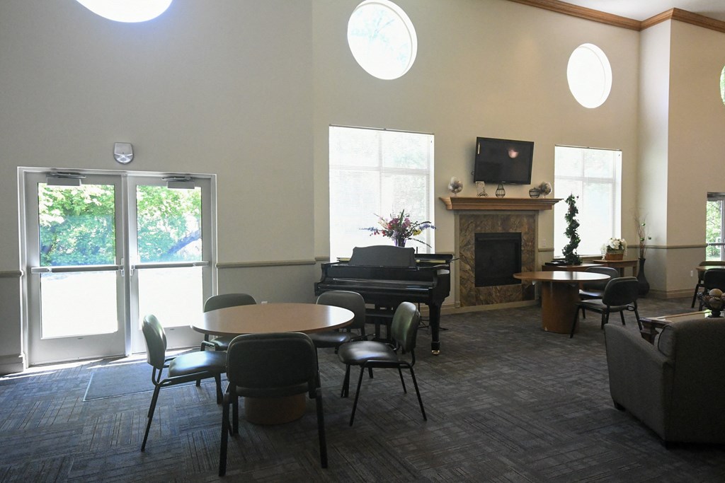 a living room with tables and chairs and a piano
