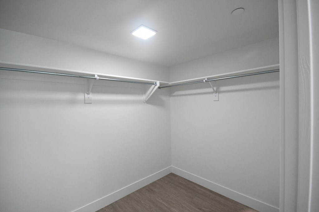 an empty room with white walls and a ceiling light