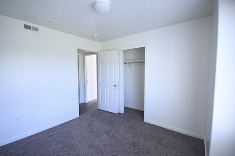 an empty room with white walls and a door to a closet