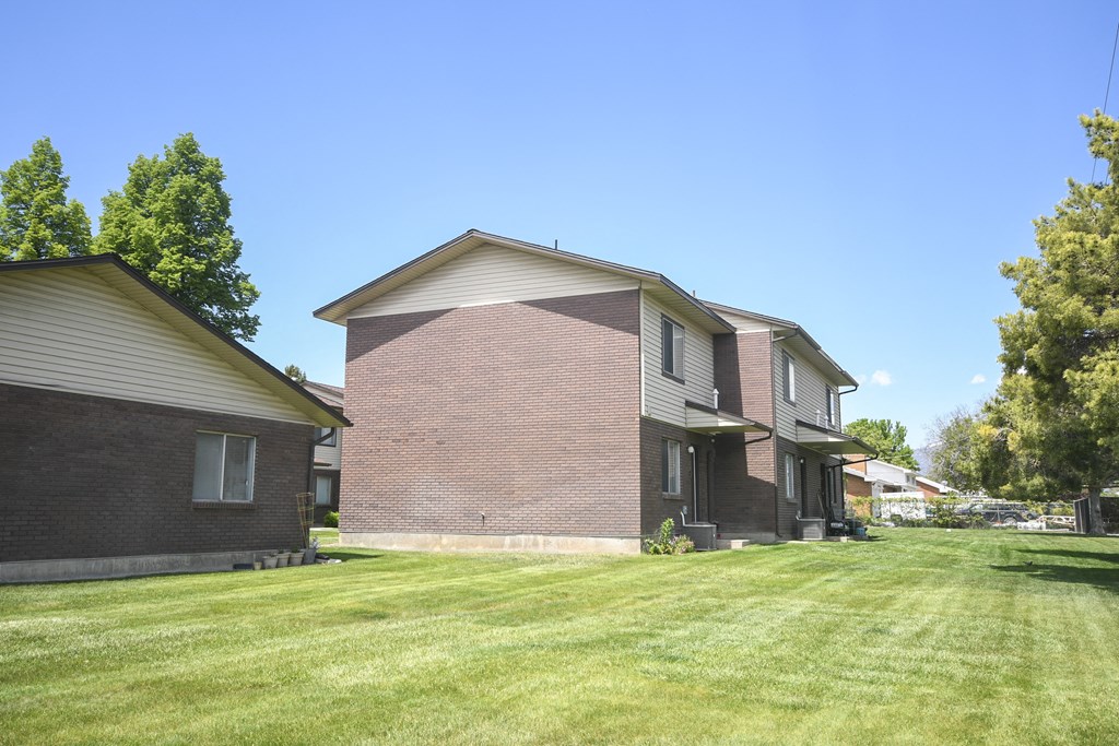 a brick house with a yard in front of it