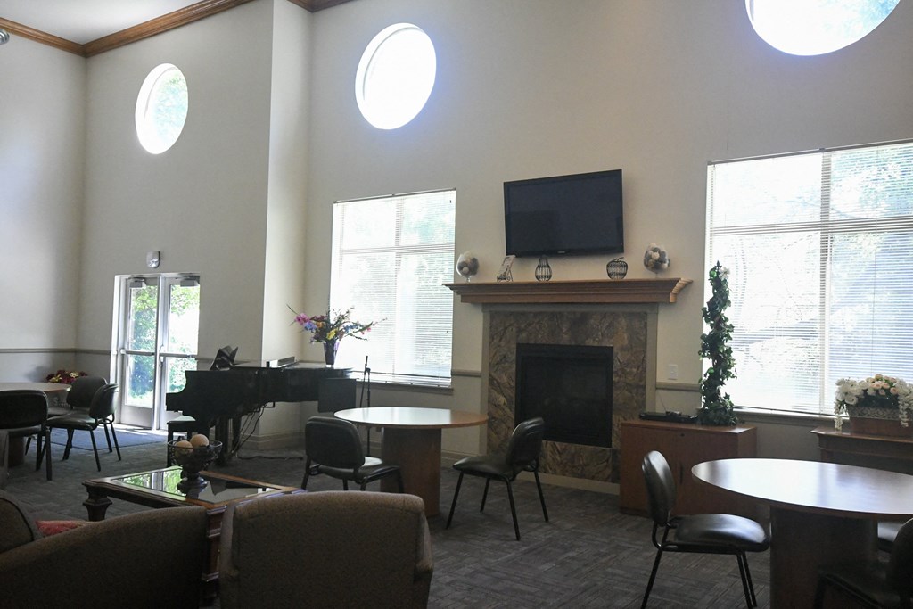 a living room with a fireplace and tables and chairs
