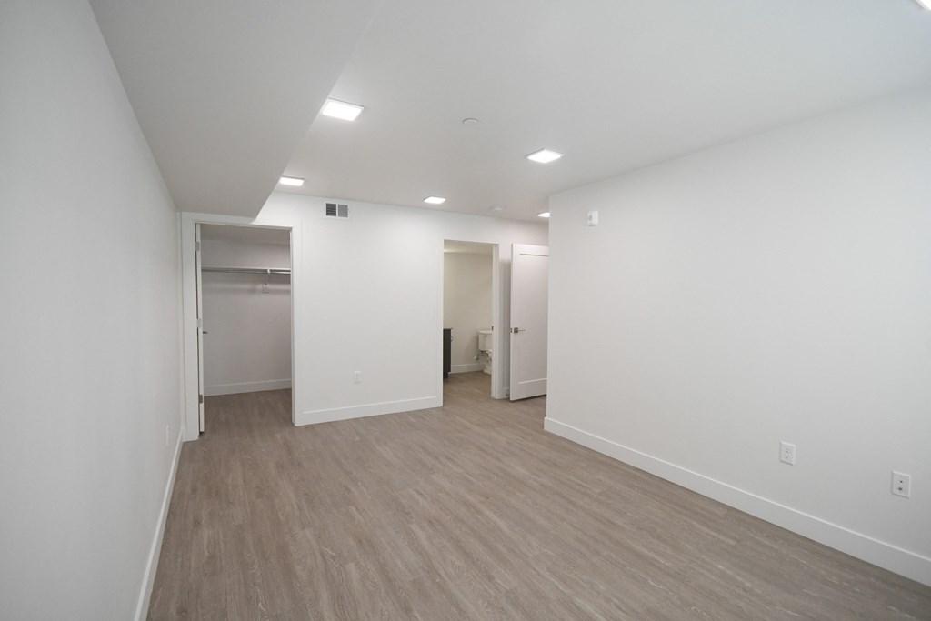 an empty living room with white walls and wood flooring