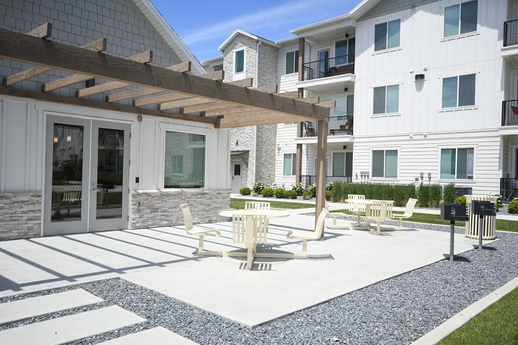 a patio with tables and chairs in front of a building