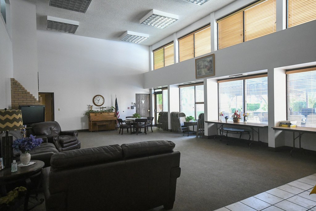 an open living room with couches and chairs and large windows
