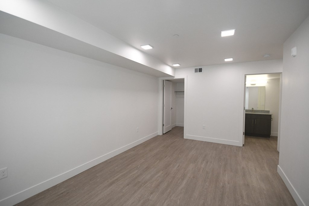an empty living room with white walls and wood floors