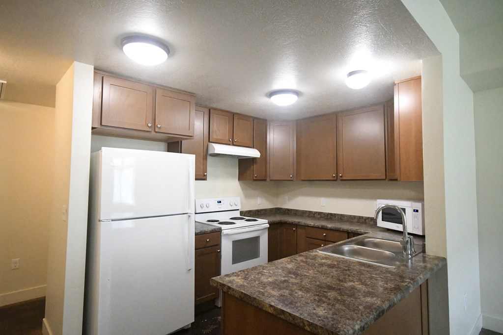 a kitchen with white appliances and granite counter tops