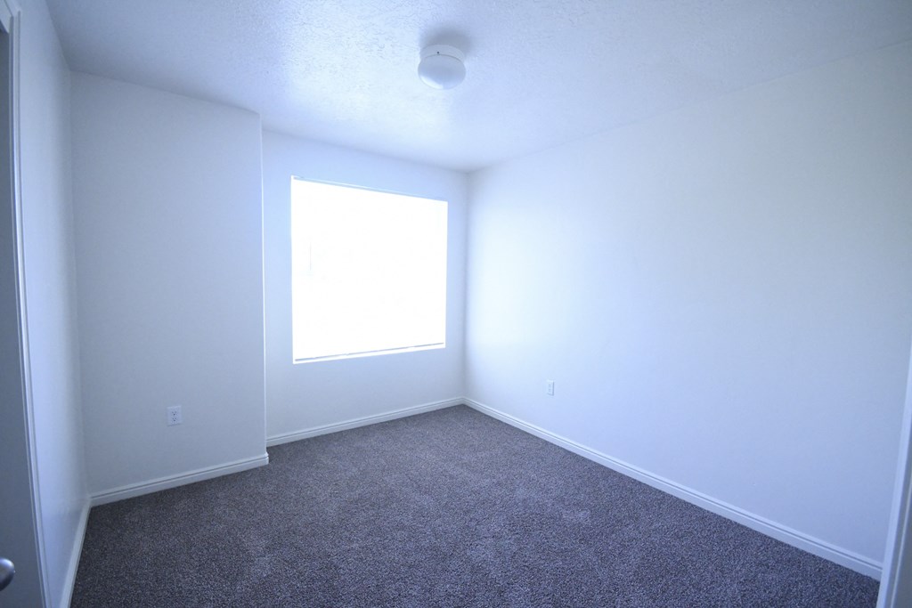 an empty room with white walls and a window