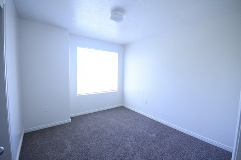 an empty room with white walls and a window