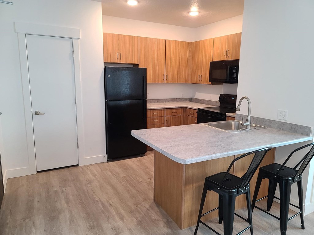 a kitchen with a island and a black refrigerator