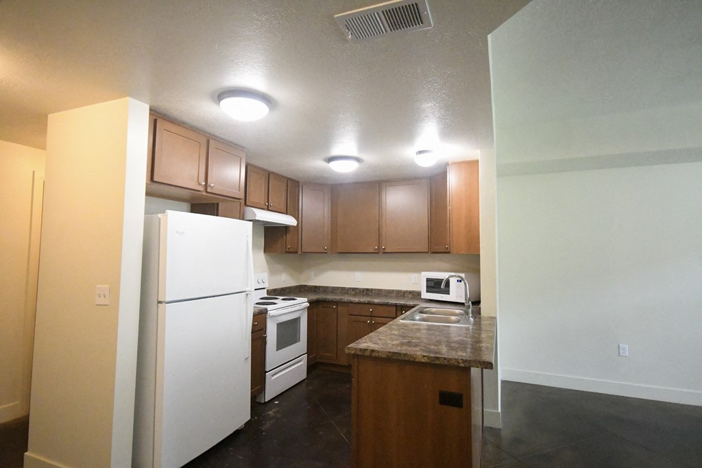 a kitchen with white appliances and wooden cabinets