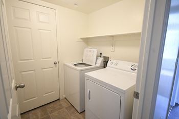 a laundry room with a washer and dryer and a white door