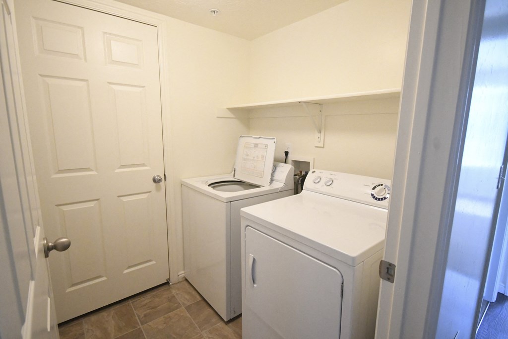 a laundry room with a washer and dryer and a white door