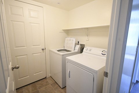 a laundry room with a washer and dryer and a white door