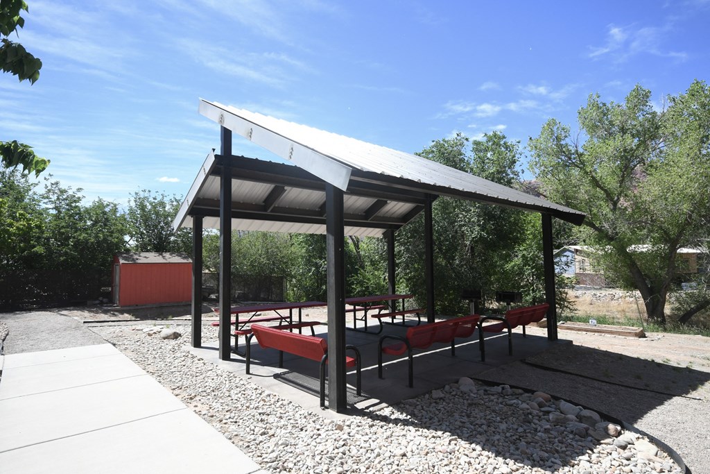 a picnic pavilion with benches and a table under it