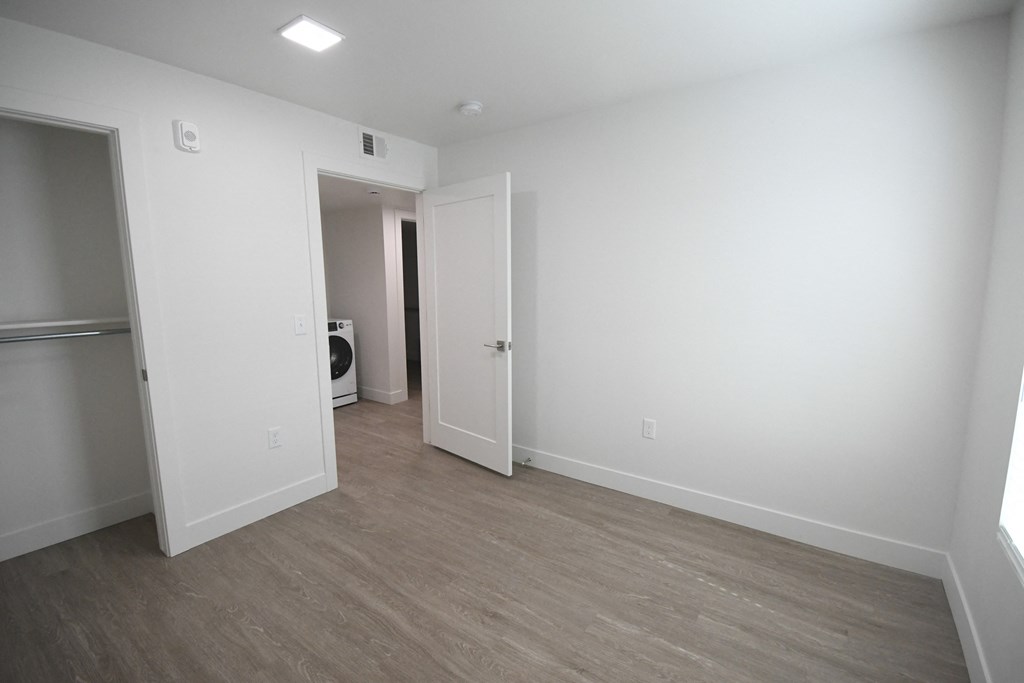an empty living room with white walls and wood flooring
