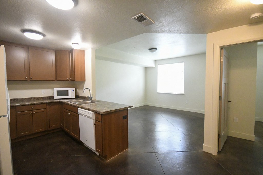 an empty kitchen with wooden cabinets and white appliances and a window