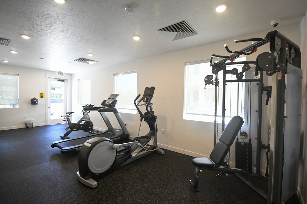 a gym with cardio machines and weights on the floor