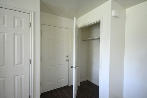 an empty room with white doors and a closet