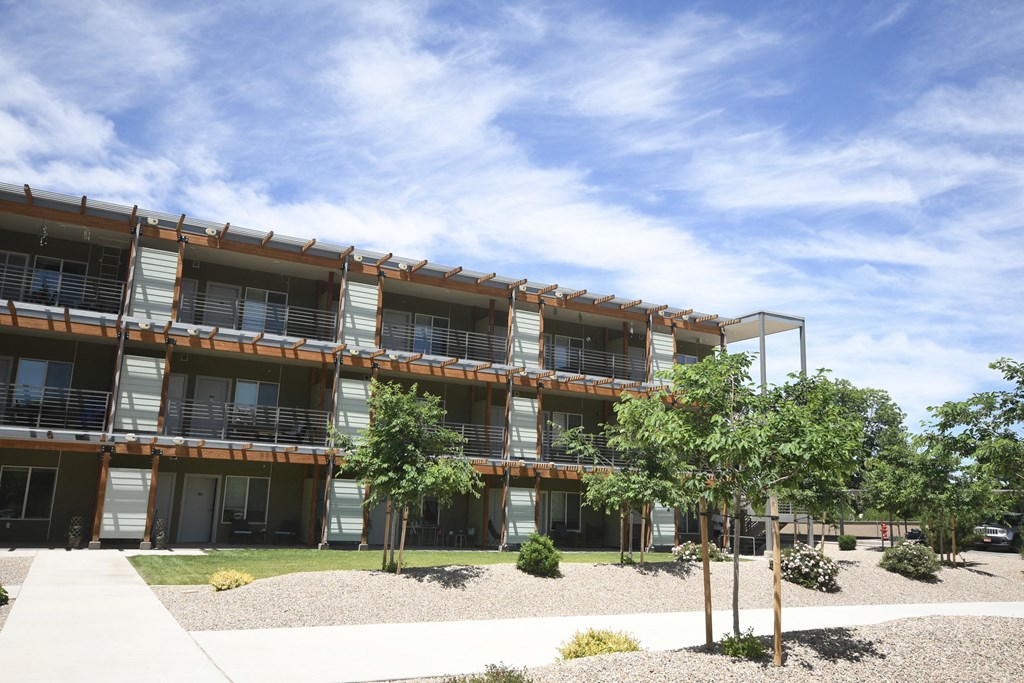 a large building with balconies and trees in front of it