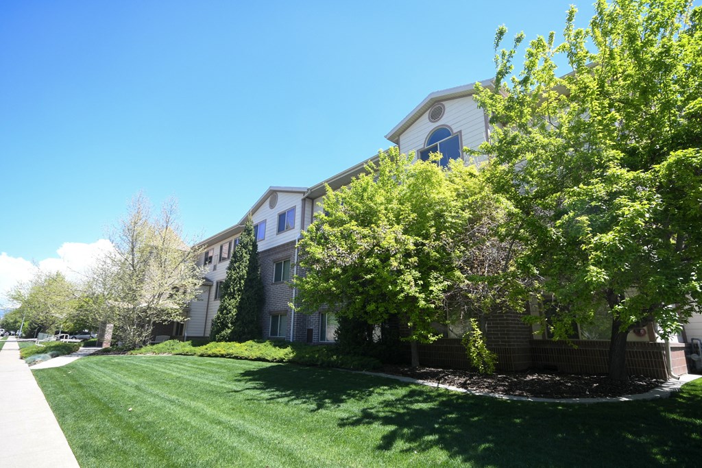 a building with a lawn and trees in front of it