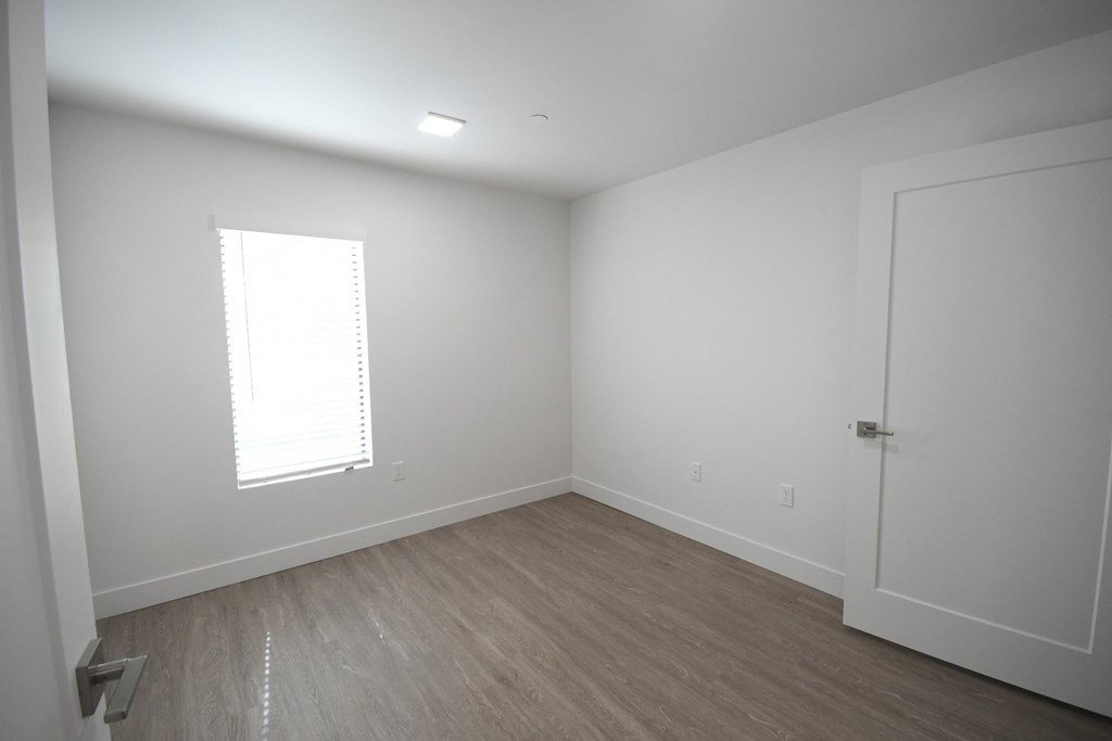 an empty room with white walls and a window