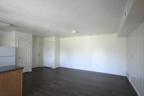 an empty living room with white walls and wood floors