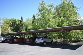a parking lot with three cars parked under a overpass