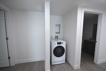 a white washer and dryer in a room with a door to a bathroom
