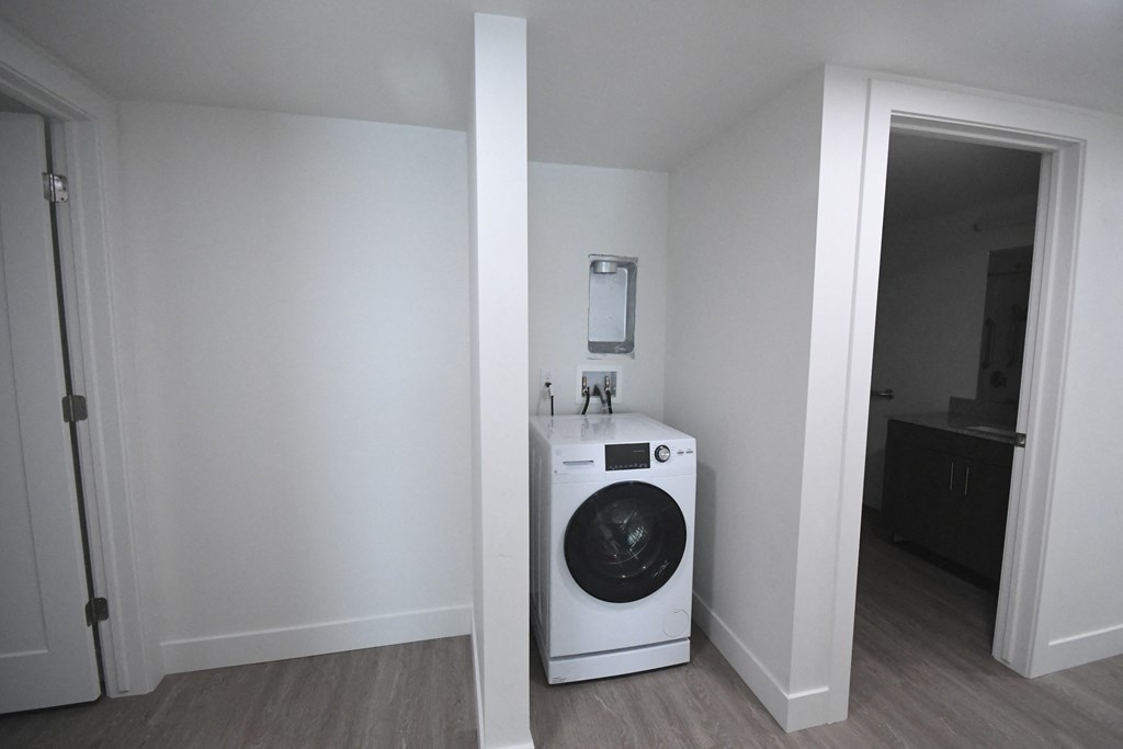 a white washer and dryer in a room with a door to a bathroom