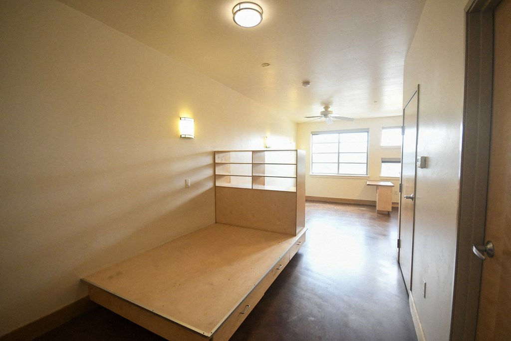 an empty room with a bench and a bunk bed