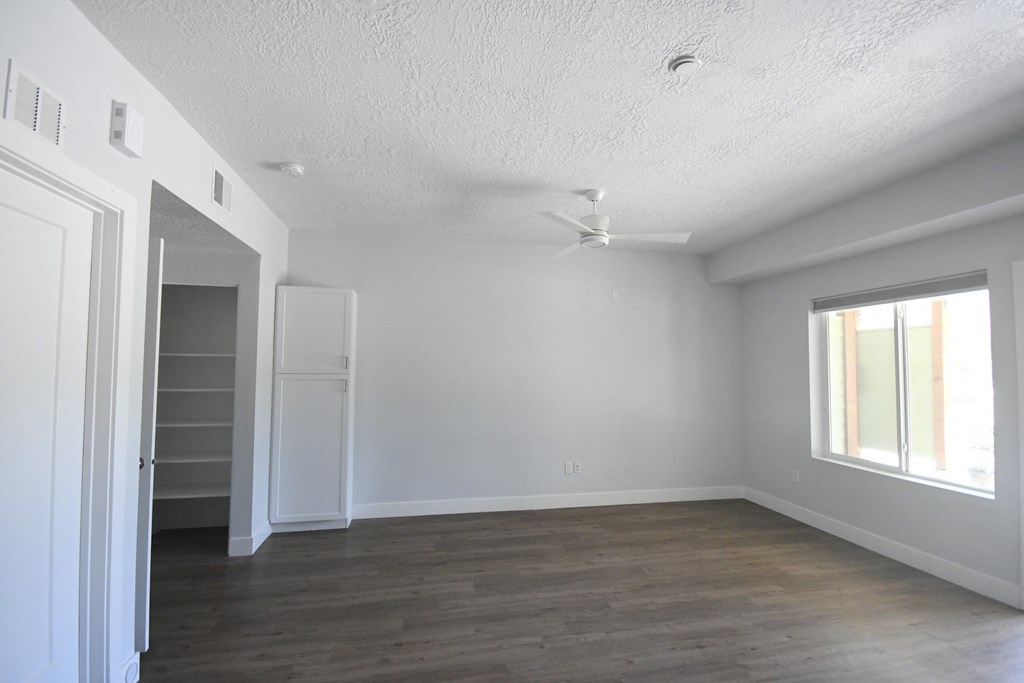 an empty living room with white walls and a closet