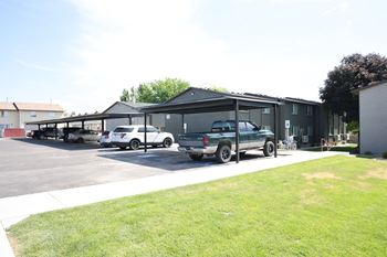 A parking lot with cars and a building in the background.