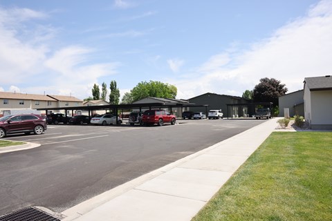 A parking lot with cars and a building in the background.