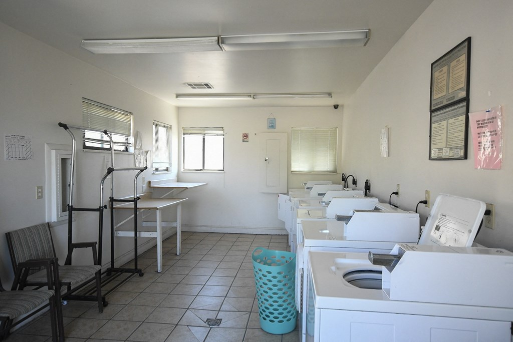an empty room with sinks and washing machines