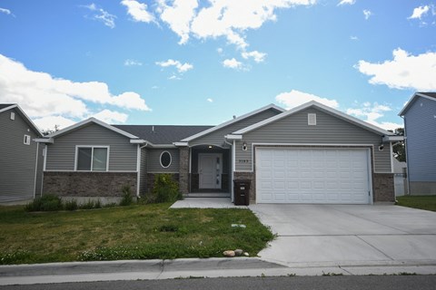 a gray house with a driveway and a garage door