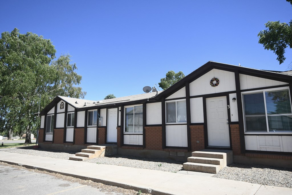 a building with white doors and a clock on the side of it