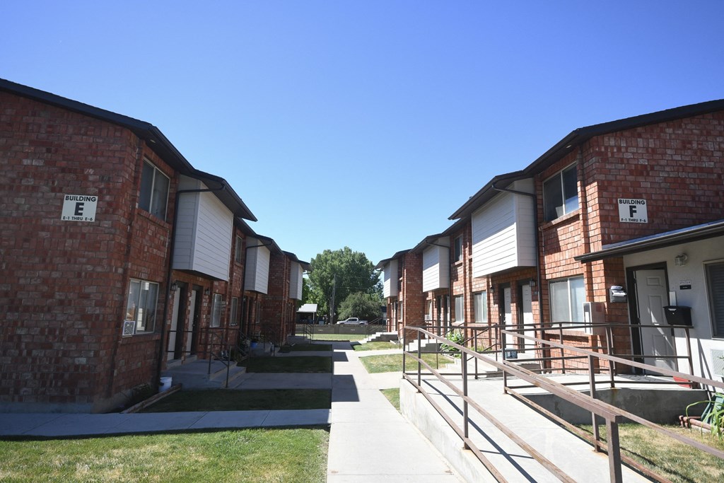 an exterior view of a row of brick apartment buildings on a sidewalk