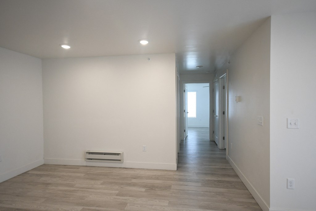 an empty room with white walls and a wood floor