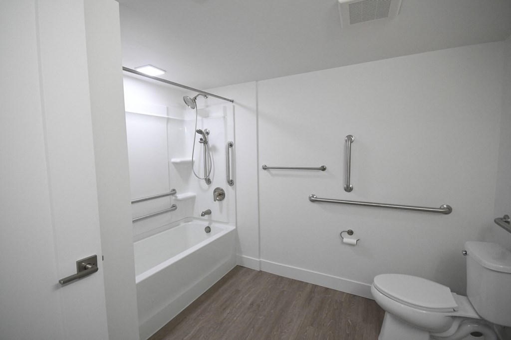 a white bathroom with a toilet and a tub and a sink