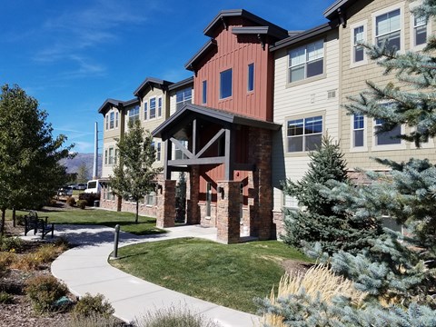 an exterior view of an apartment building with a walkway