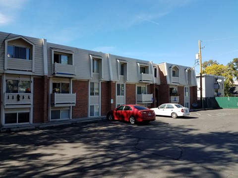 a red car parked in front of an apartment building