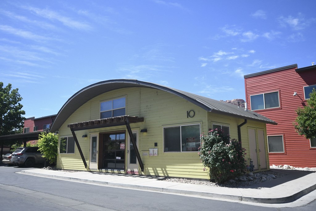 the front of a yellow building with an oddly shaped roof