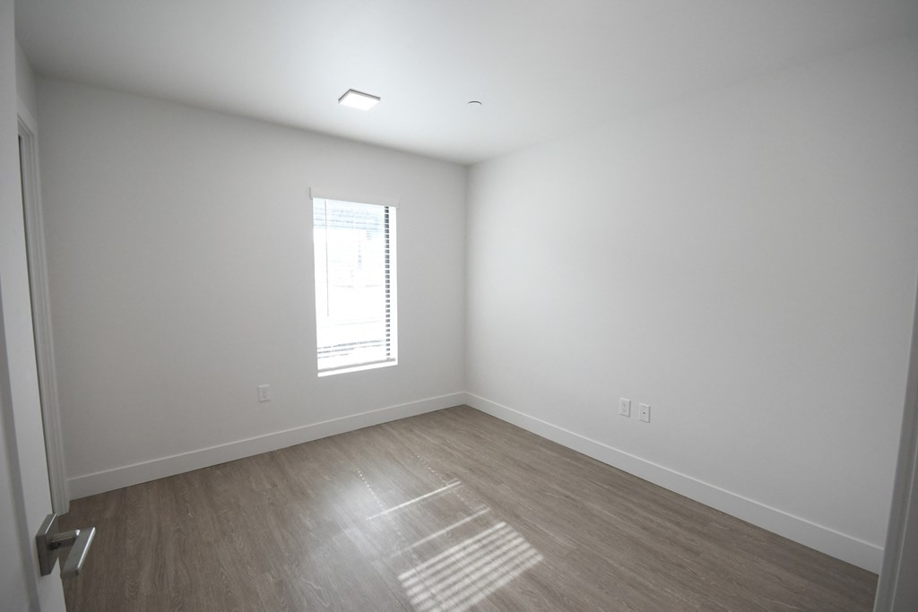an empty room with white walls and a window