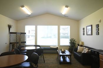 a living room with a large window and a table and chairs