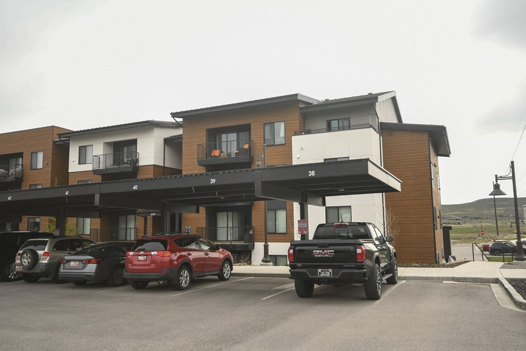 a large apartment building with cars parked in front of it