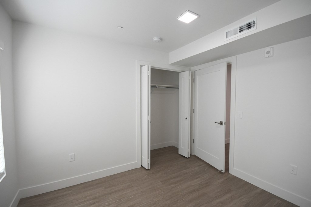 an empty room with white walls and a door to a closet