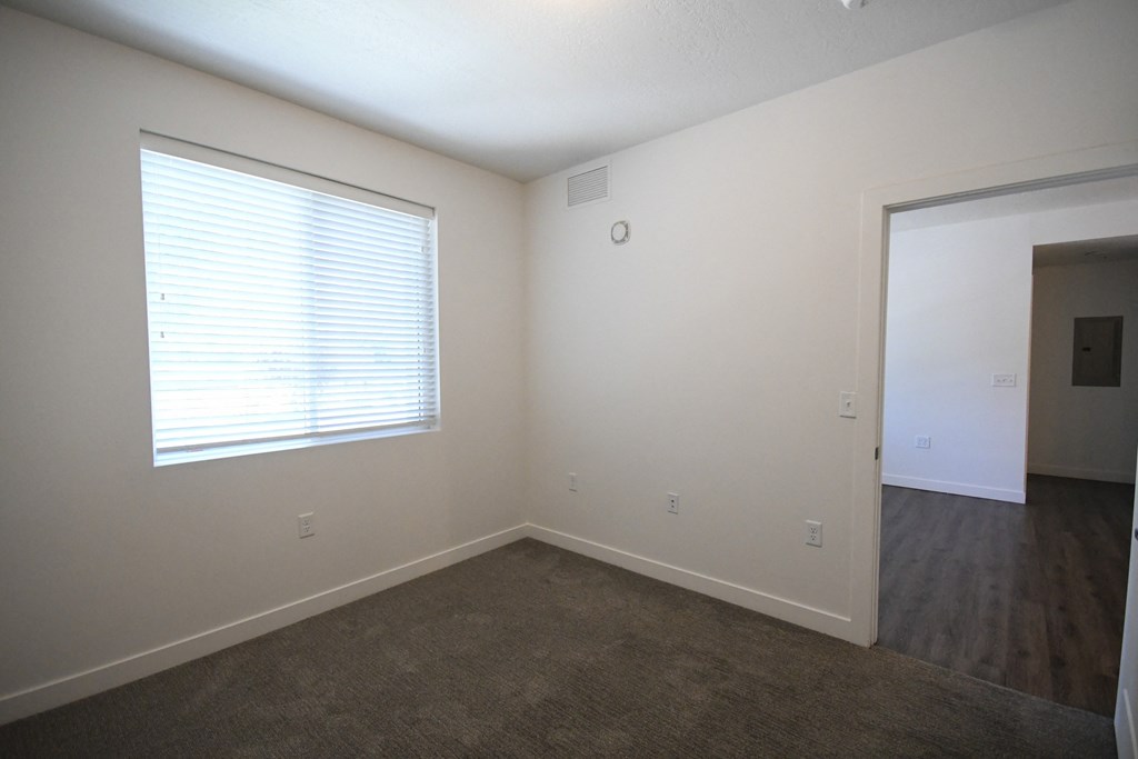 an empty room with a window and a door