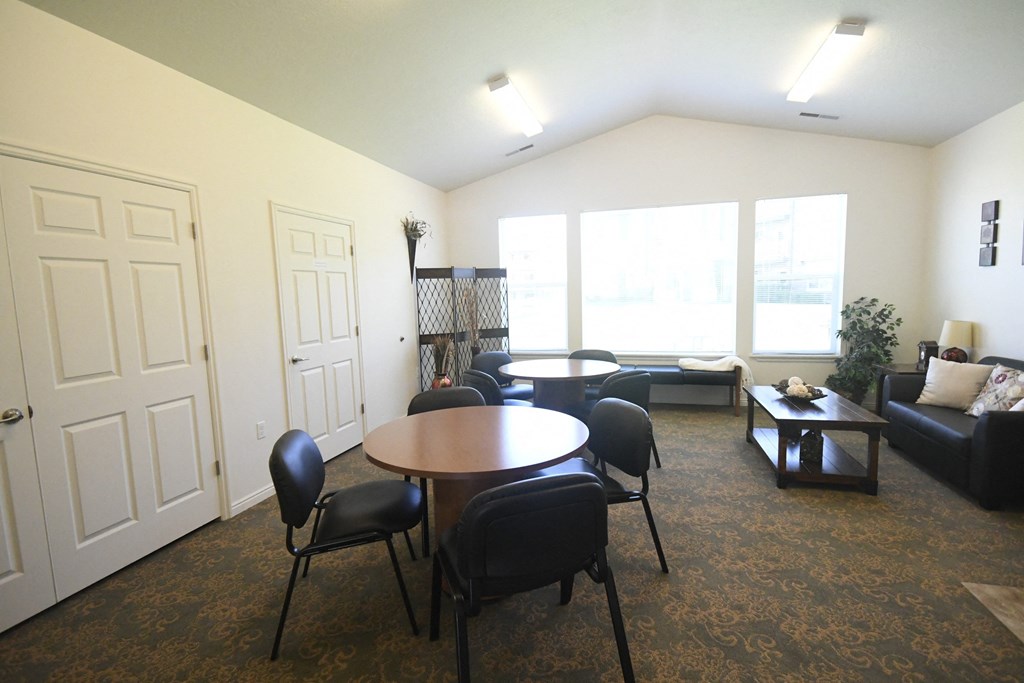 an empty living room with a table and chairs