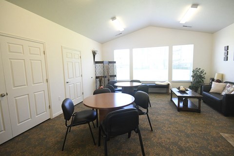 an empty living room with a table and chairs